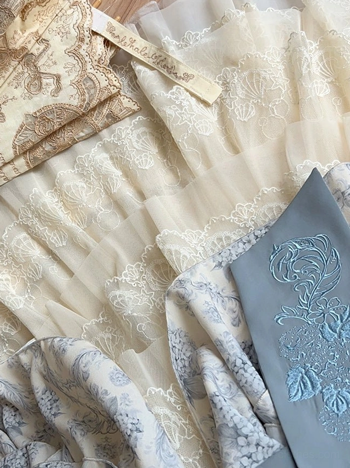 Lolita petticoat fabric detail flat lay showing embroidered floral lace tulle construction with blue embroidered fabric swatch displaying vintage pattern