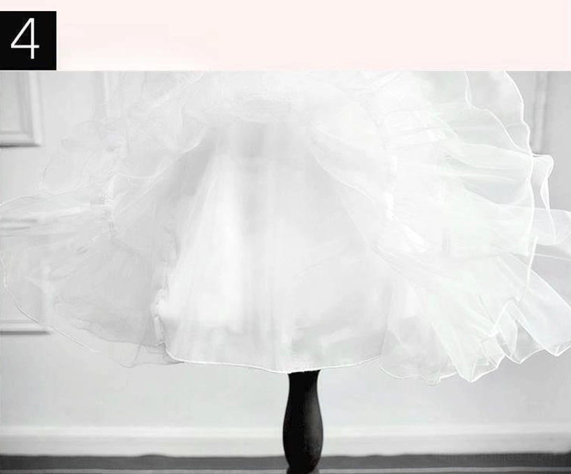 Low-angle close-up of white Lolita petticoat fluffy ruffled hem edge on mannequin leg showing stiff tulle finish and volume