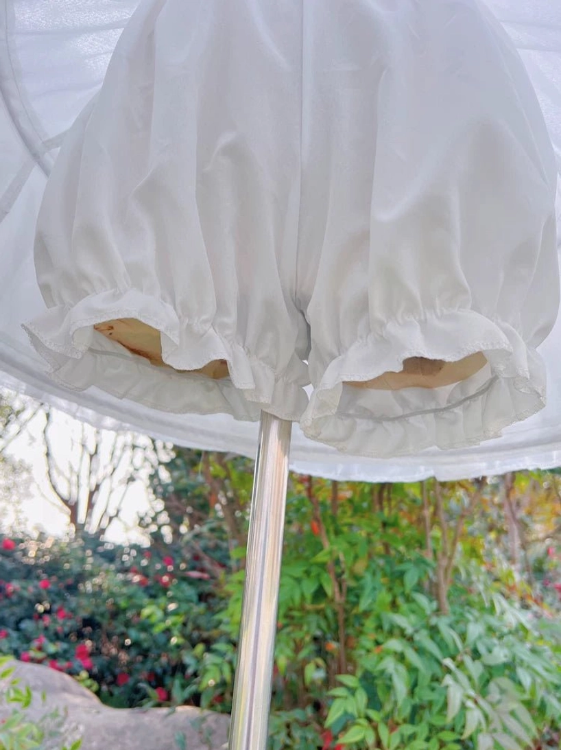 Close-up lolita petticoat bottom hem ruffled edge detail soft matte white chiffon fabric outdoor