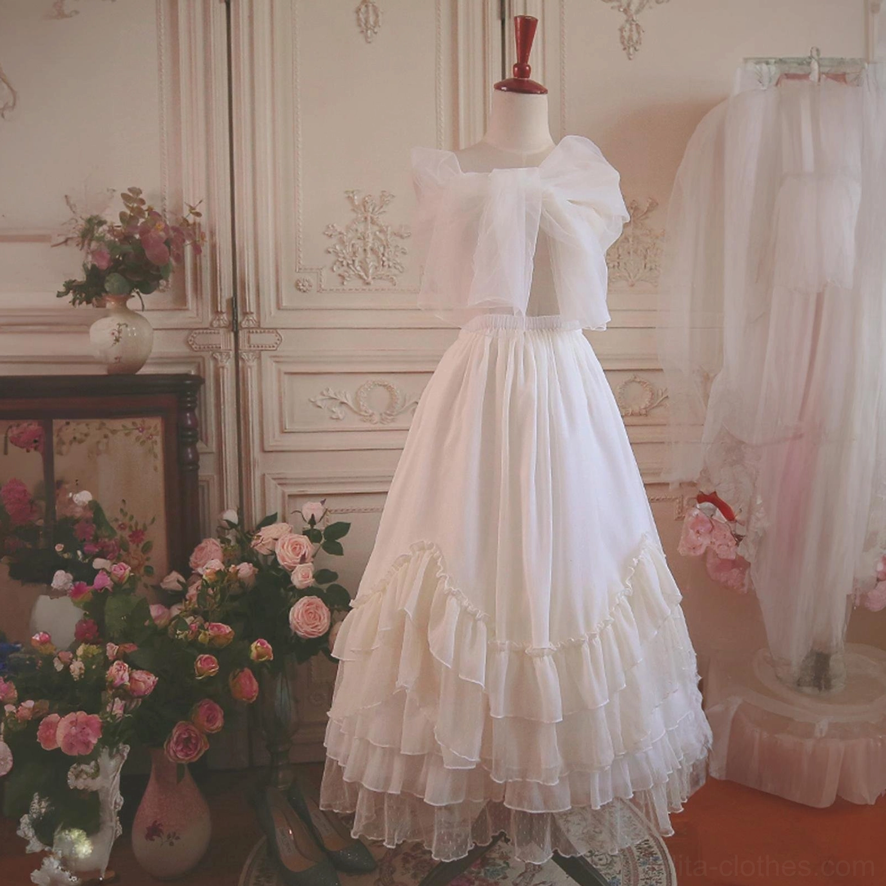 Off-white Lolita petticoat on dress form showing bow-knot decorative waist detail tiered ruffled hem flowy tulle fabric