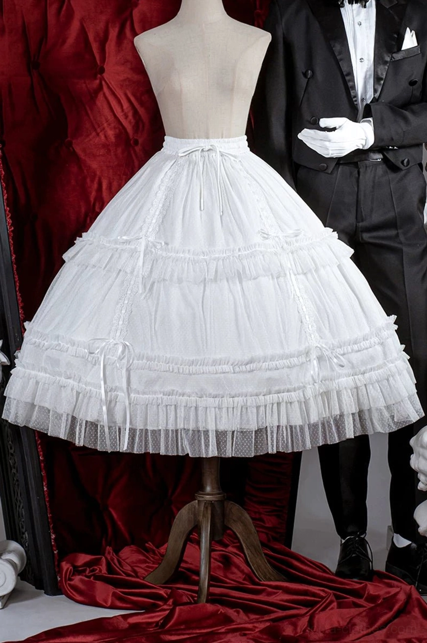White lolita petticoat with multi-layer tulle ruffles displayed on mannequin with red velvet backdrop, showing drawstring waist and satin ribbon trims