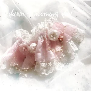 pink lolita ruffle wrist cuffs with pearl chain accents and floral embroidery on glittering tulle backdrop