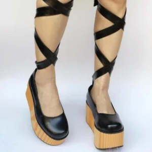 Platform lolita bridal shoes three-quarter view showing wood-grain wedge sole and ankle strap styling on model