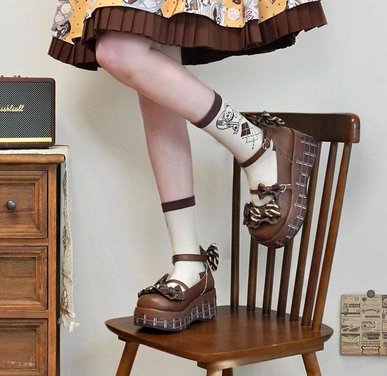 Brown leather-style lolita platform shoes with bowknot decorations chunky platform sole and vintage texture placed on wooden chair with printed socks