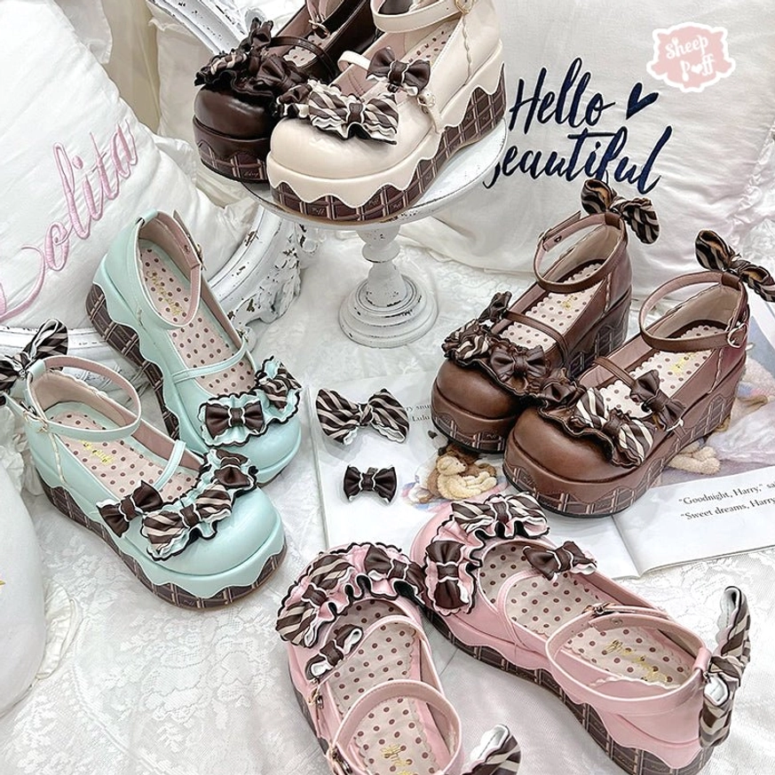 Multiple pairs of lolita platform shoes in brown mint green and pink shades with bow decorations polka dot insole and chocolate-patterned chunky sole flatlay display