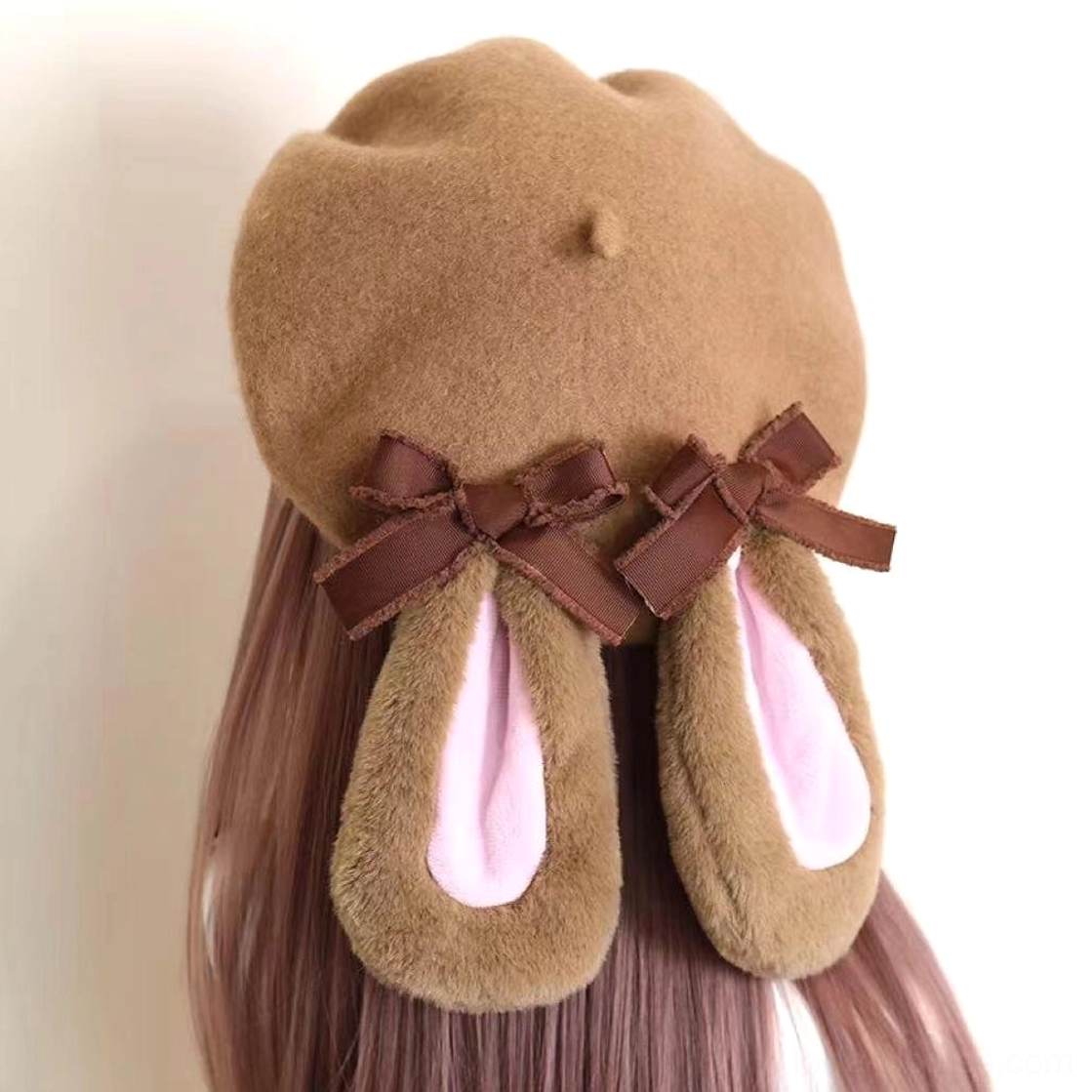 Camel-pink plush rabbit ear beret with dual brown satin bows front three-quarter view on mannequin with pink wig Lolita winter hat