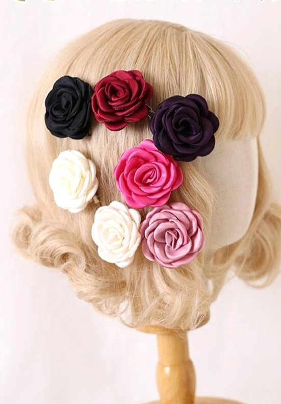 Rear close-up view of multi-piece fabric rose hair clips attached to blonde Lolita mannequin head showing six mixed-color options