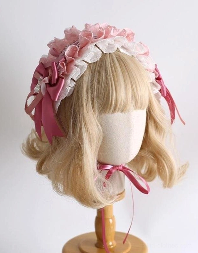 Sweet lolita fancy ruffled bow hairband side three-quarter view without bunny ears on mannequin wooden display stand pink and white lace trim dark pink satin bows