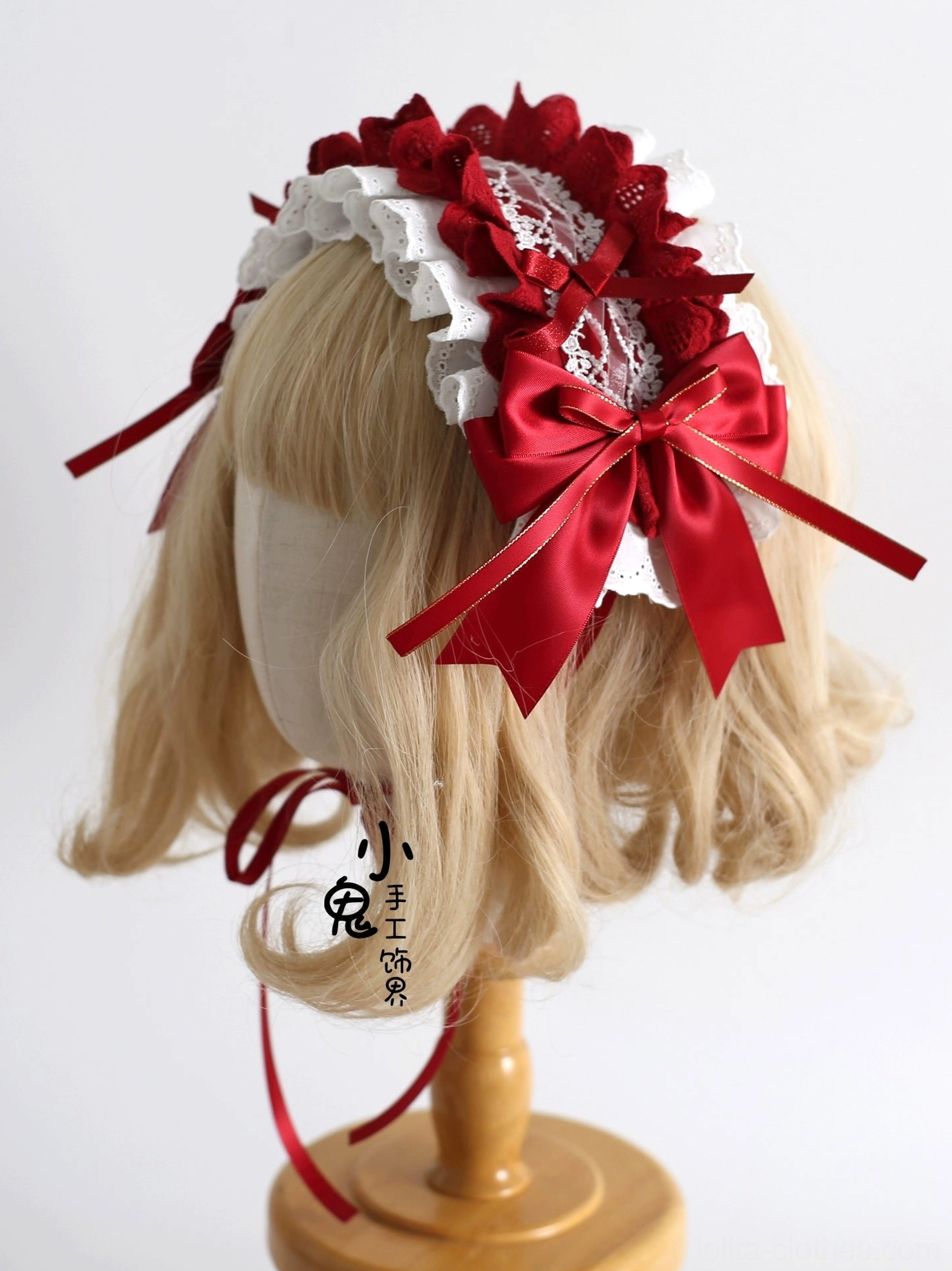Sweet lolita side-mounted satin bow hair accessory with large central red bow, white ruffled lace base, and long adjustable ribbon straps - side close-up on mannequin