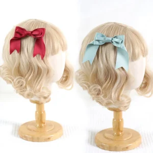 Lolita satin bow hair clips red and mint blue colors displayed on curly blonde wig mannequins showing front and back views perfect for J-fashion aesthetic