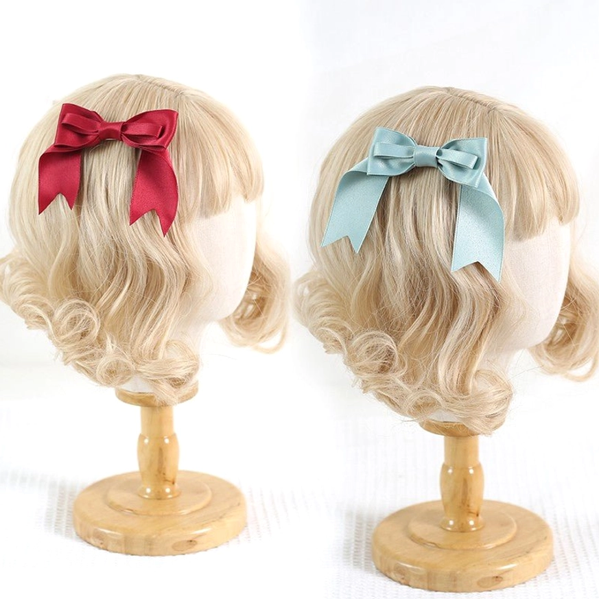 Lolita satin bow hair clips red and mint blue colors displayed on curly blonde wig mannequins showing front and back views perfect for J-fashion aesthetic