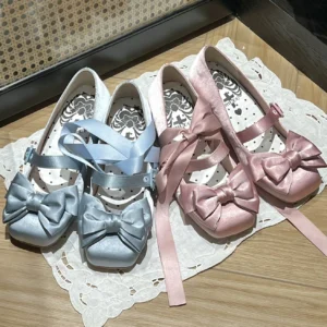 Flat lay view of elegant lolita satin square toe Mary Jane shoes with oversized satin bow on white lace placemat, showing baby blue and pink colorways