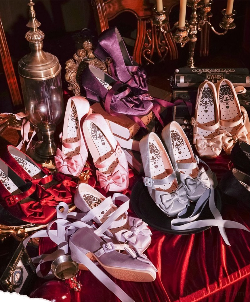 Assorted lolita satin shoes flat lay display on vintage red velvet fabric with antique decor showing multiple color options and square toe design