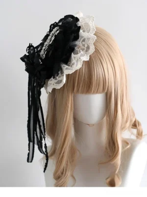 Small black bowler hat with ivory lace trim and hanging tulle streamers, front three-quarter view on mannequin, lolita hat accessory