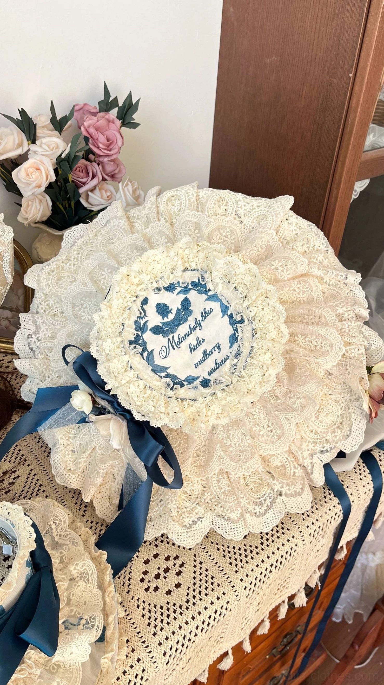Large round straw bonnet lolita headdress with crochet cream lace ruffle base porcelain print panel and dark blue satin bow fabric flower details