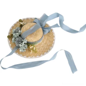 Haze blue lolita wheat straw wide-brim sunhat with sky blue ribbons and grey-blue artificial flower decoration, white lace-trimmed brim, top-down side view on white background