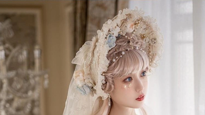 Half-body Lolita tea party outfit on model in cream off-shoulder dress with floral details, matching headdress, pearl necklace, and veil