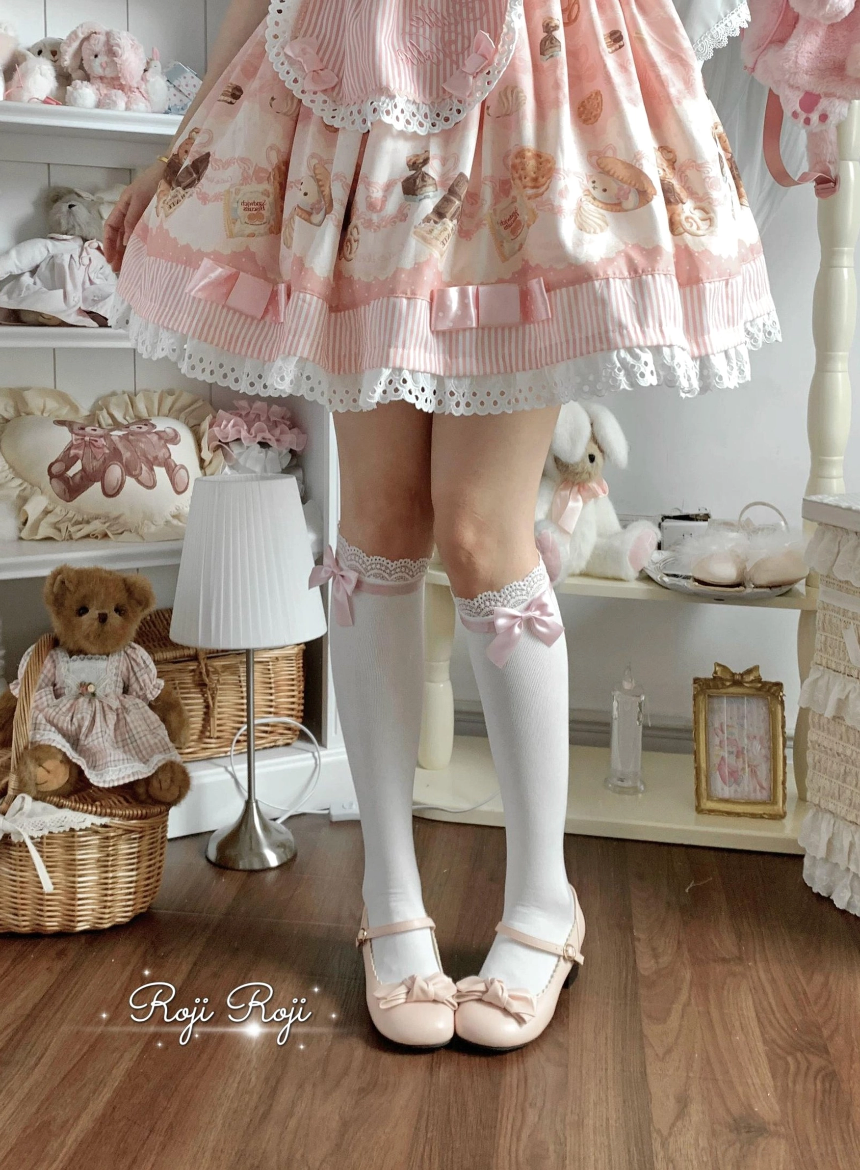 White lolita thigh-high socks with lace trim cuff bow detail paired with pink Mary Jane shoes front low angle view sweet lolita