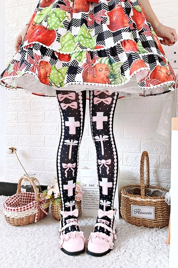 Black and pink lolita thigh high stockings featuring cross bow and dot motifs, paired with fruit print black lolita dress