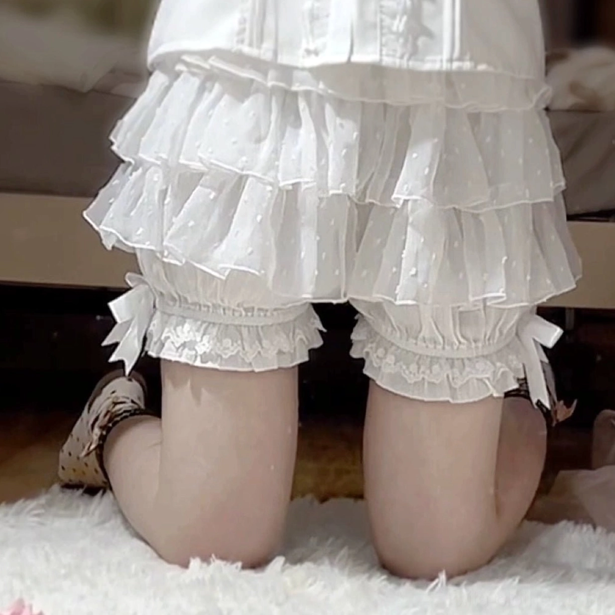 Lolita tiered ruffle bloomers complete product flat lay composition showing full garment with ribbon bows lace details ruffled layers and overall silhouette aesthetic presentation