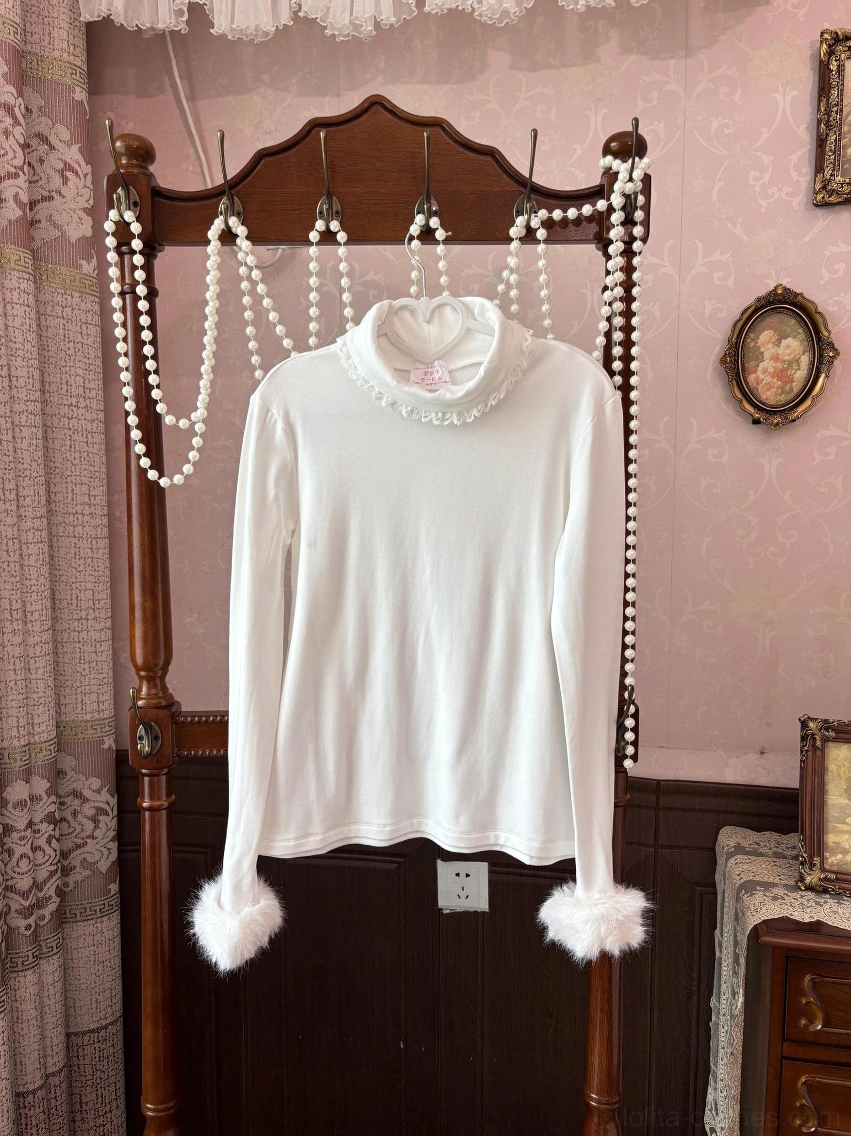 White lolita high-neck turtleneck inner wear hanging on vintage wooden clothes rack showing slim fit lace-trimmed neckline and fluffy fur cuffs
