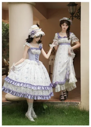 Twin sweet lolita models in blue iris dresses with different lengths showing JSK and OP styles at outdoor cottage porch with layered purple ruffled hem
