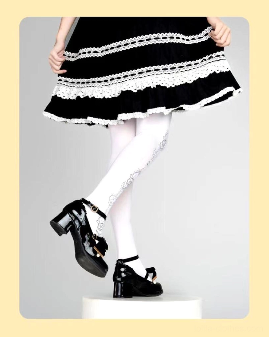 Side profile leg view of printed white velvet Lolita pantyhose with elaborate black vintage prints worn with black bow-strap Mary Jane heels