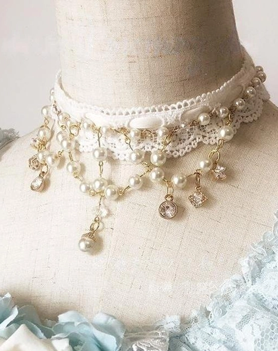 Lolita vintage pearl choker necklace with white lace base, layered pearl chains, and dangling gemstone pendants displayed on fabric dress form paired with light blue Lolita dress in neck close-up view