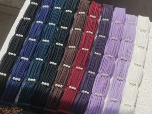 assorted lolita waist sash belts with navy blue brown wine red purple and white colors ruched pearl-trimmed panels on dark wooden table