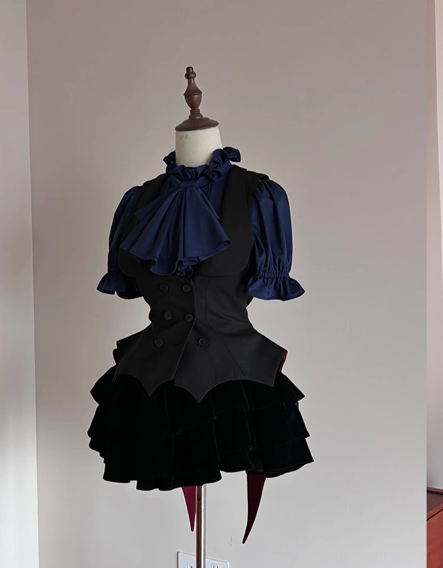 Gothic Lolita two-piece outfit displaying black waistcoat with bat hem paired with navy ruffled bow blouse and black ruffled mini skirt, left three-quarter angle
