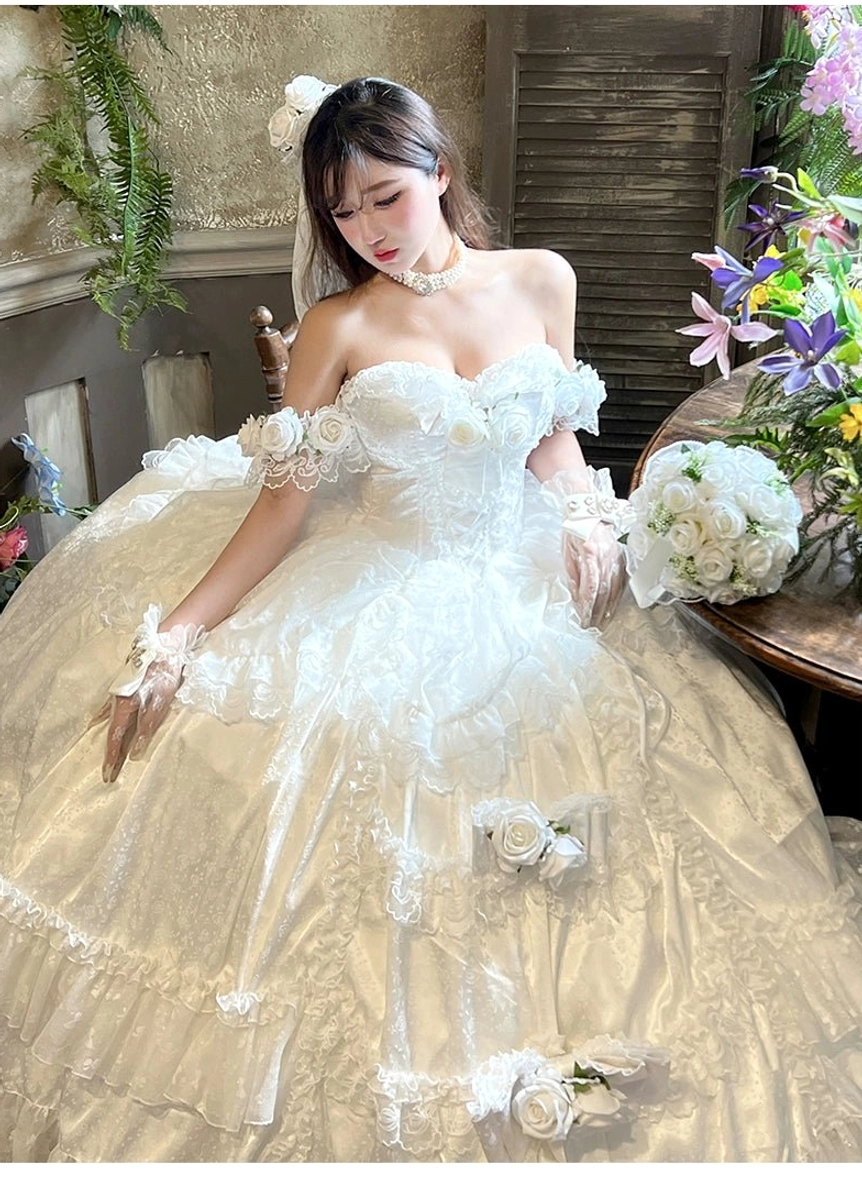 Side full-body shot of off-shoulder princess lolita wedding gown with white tulle and rose appliqués