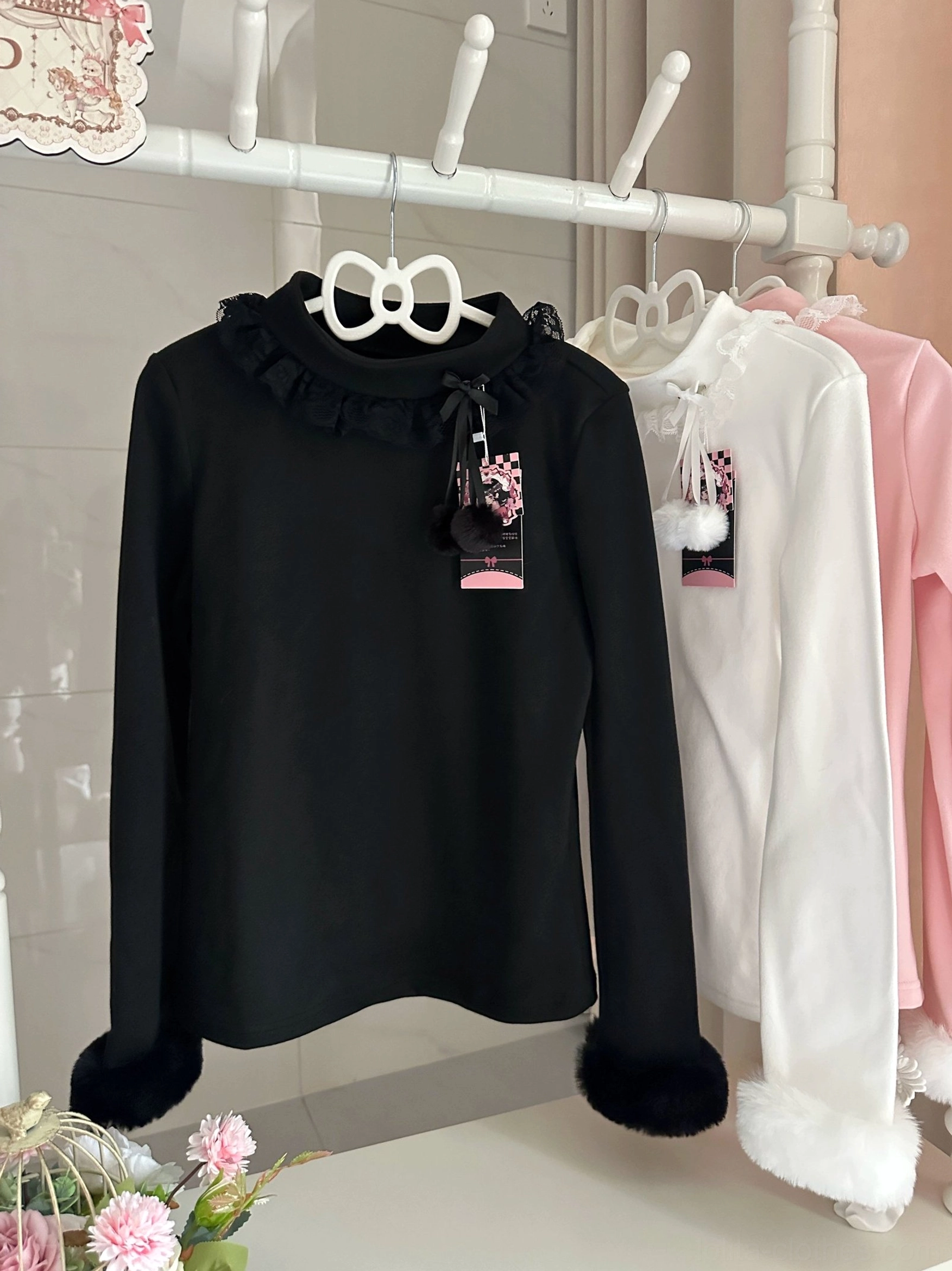Black Lolita style winter inner long-sleeve top with fluffy faux fur cuffs and ruffled lace turtleneck on boutique display rack