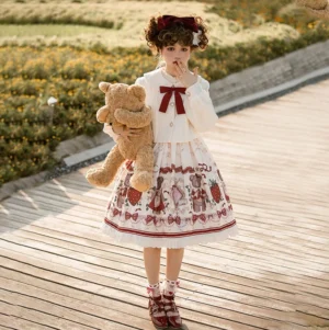 Outdoor full-body lolita winter coordinate girl model holding teddy bear wearing peter pan coat and printed jsk dress on waterfront path