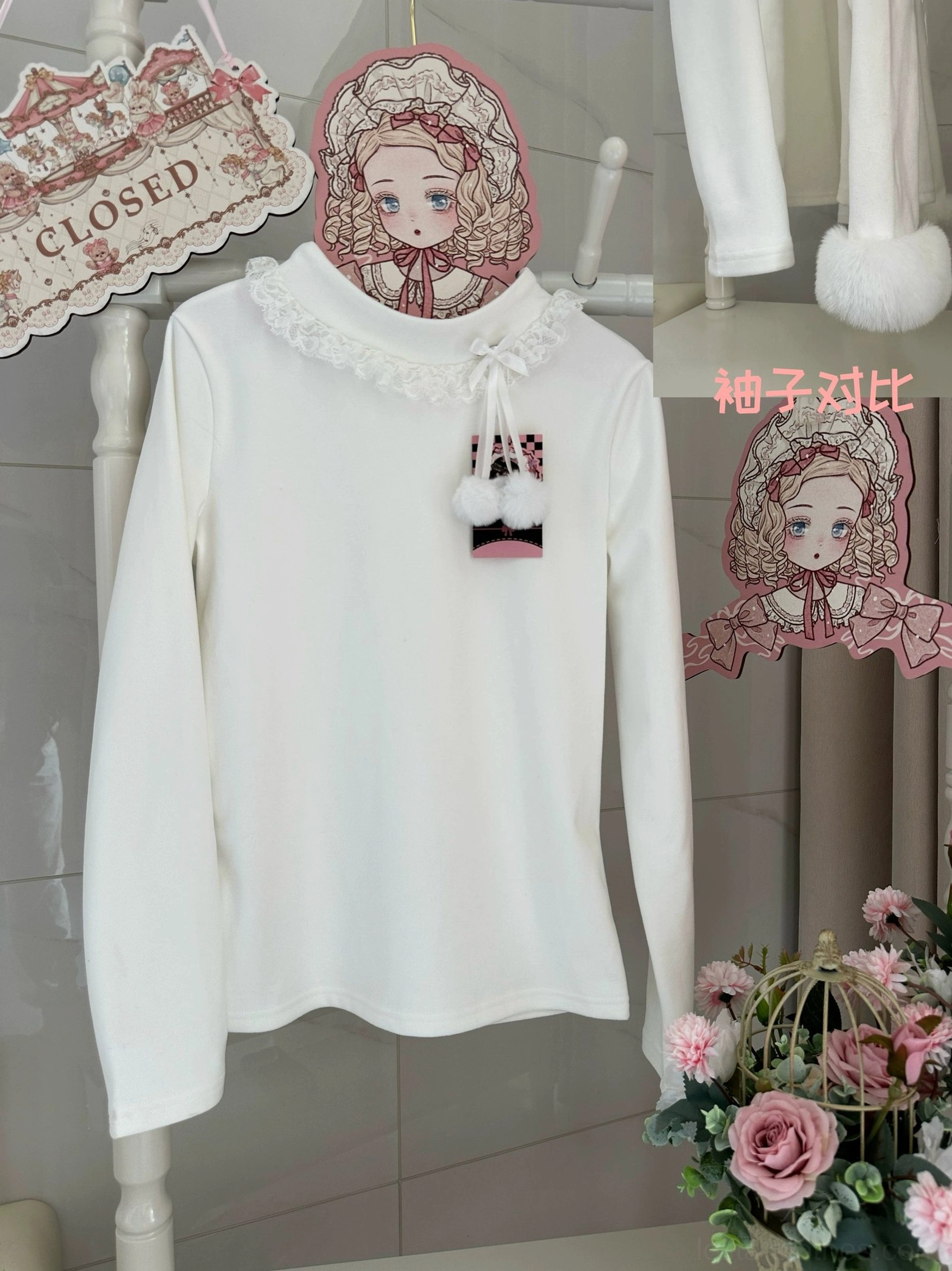 White Lolita innerwear without fuzzy cuffs with lace-trimmed turtleneck and pompom product hangtag on display rack with floral decor