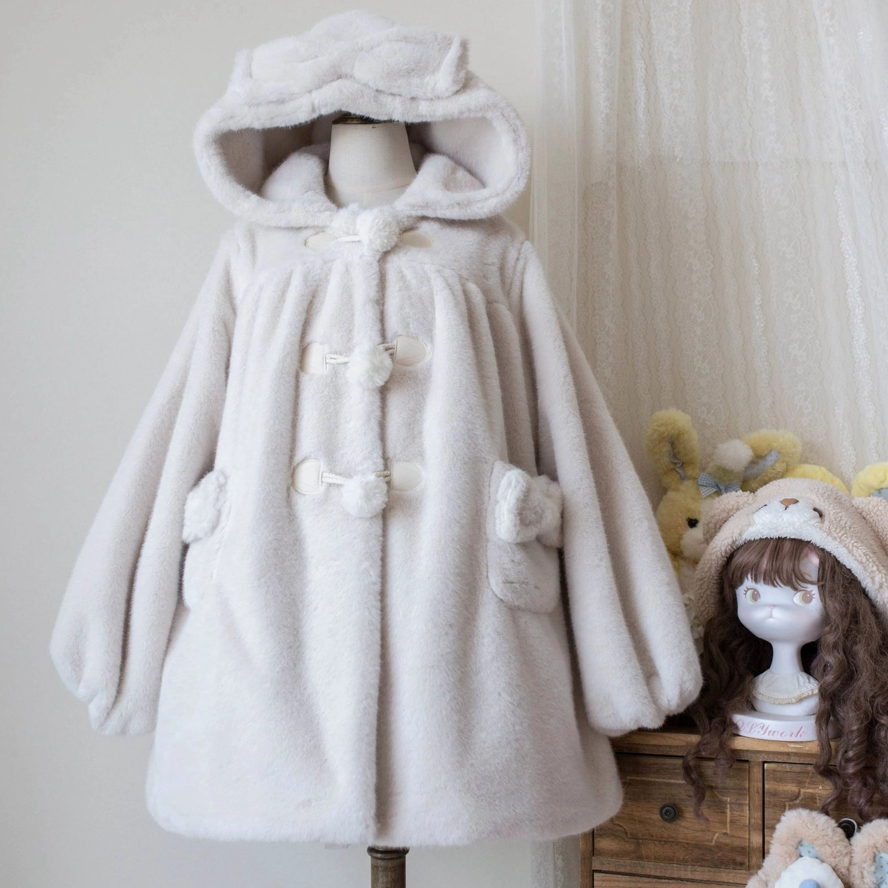 Lolita winter thickened fluffy overcoat showing faux mink fur exterior texture, bear ear hood design and ruffled hem detail in coordinated styling