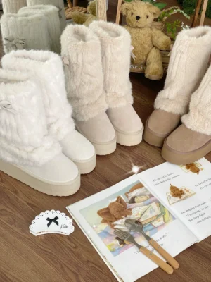 Flat lay overhead display of cream white and tan lolita winter plush mid-calf boots with bow accents and fluffy fur collar, styled with teddy bear and fashion accessories on wooden table