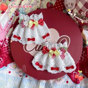 Sweet Lolita wrist cuffs with white hollow lace base, yellow satin bows, red gingham bows and red polka dot bows displayed on red round tray with strawberry fabric backdrop