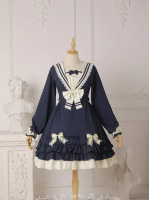 Long-sleeve navy blue sailor sweet lolita one-piece dress with white sailor collar trim, large decorative front bow, and layered ruffled lace-trimmed hem displayed on wooden mannequin