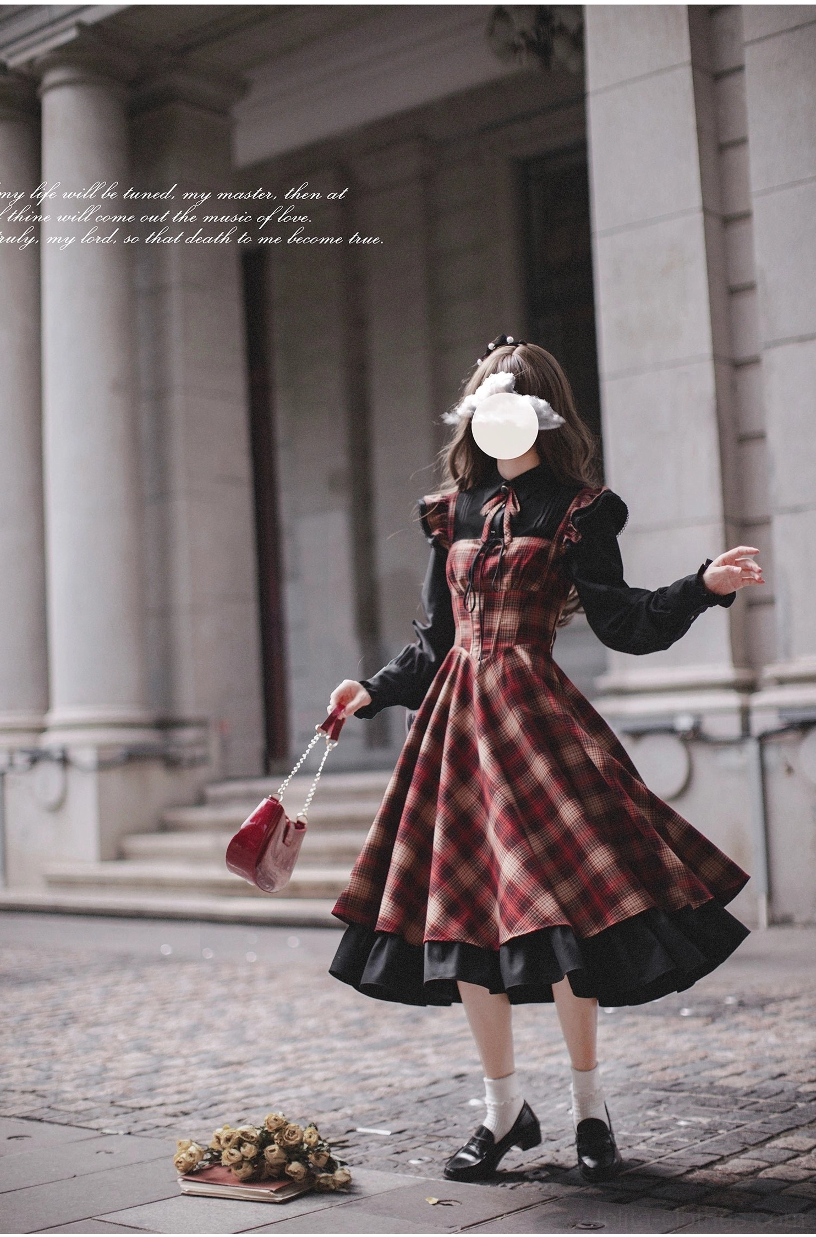 Madeleine lolita ensemble with red plaid JSK, black blouse featuring ruffled cuffs, holding vintage red leather handbag - side turning three-quarter body view in classical stone corridor