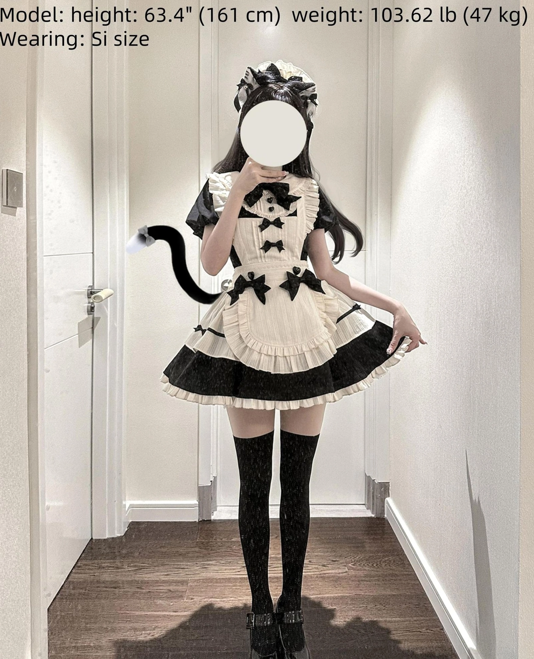 Short-sleeve maidette lolita OP dress with cat tail accessory on model wearing black thigh-high socks platform shoes and cat ear headbow in hallway