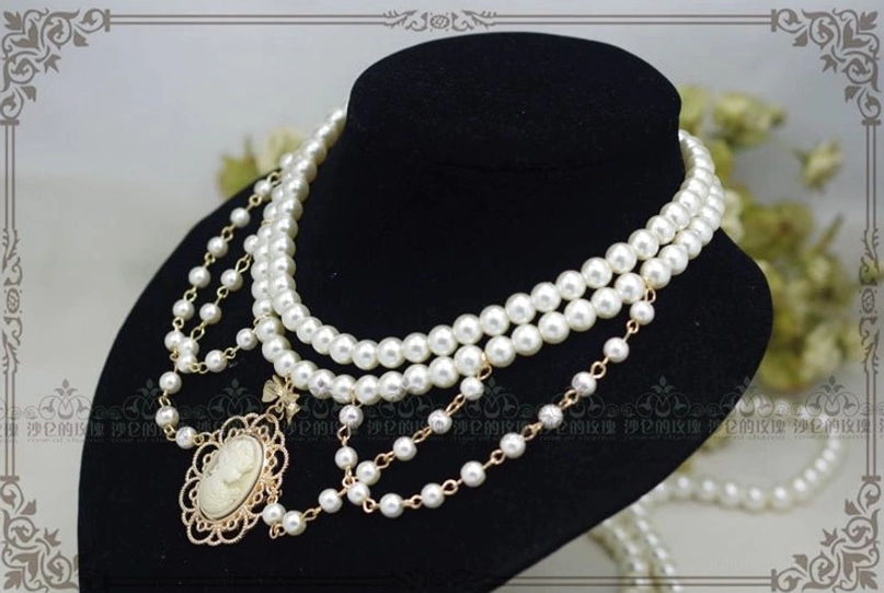 Manor Ball II cameo pearl necklace delicate bow tie pendant accent detail golden brown vintage portrait artwork closeup jewelry photography