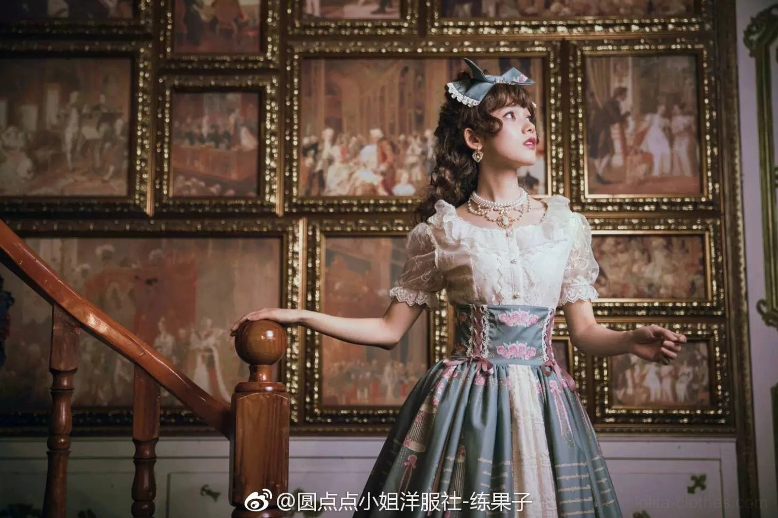Lolita girl model in white-blue vintage dress with blue bow wearing delicate Manor Ball II cameo pearl necklace indoor corridor with classical framed paintings