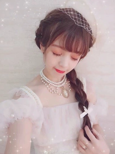 Lolita model wearing white pearl Manor Ball II cameo necklace with pink ruffled square neck dress and braided hair veil accessory soft dreamy indoor styling