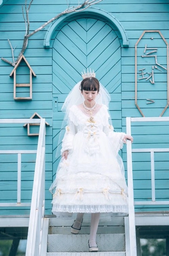 Bride-style lolita model in white ruffled wedding dress with crown veil wearing Manor Ball II cameo pearl necklace on retro teal wooden house staircase