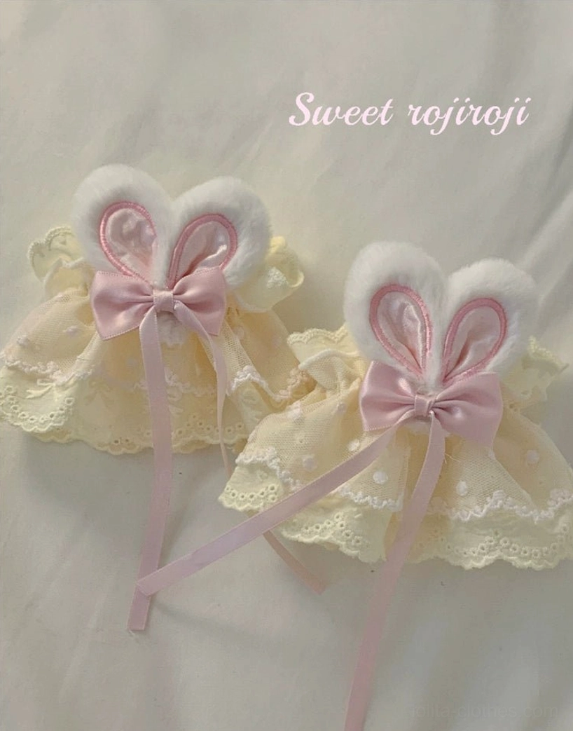 Matching cream yellow rabbit ear lace wrist cuffs identical satin bows plush ears ribbon tails top down view