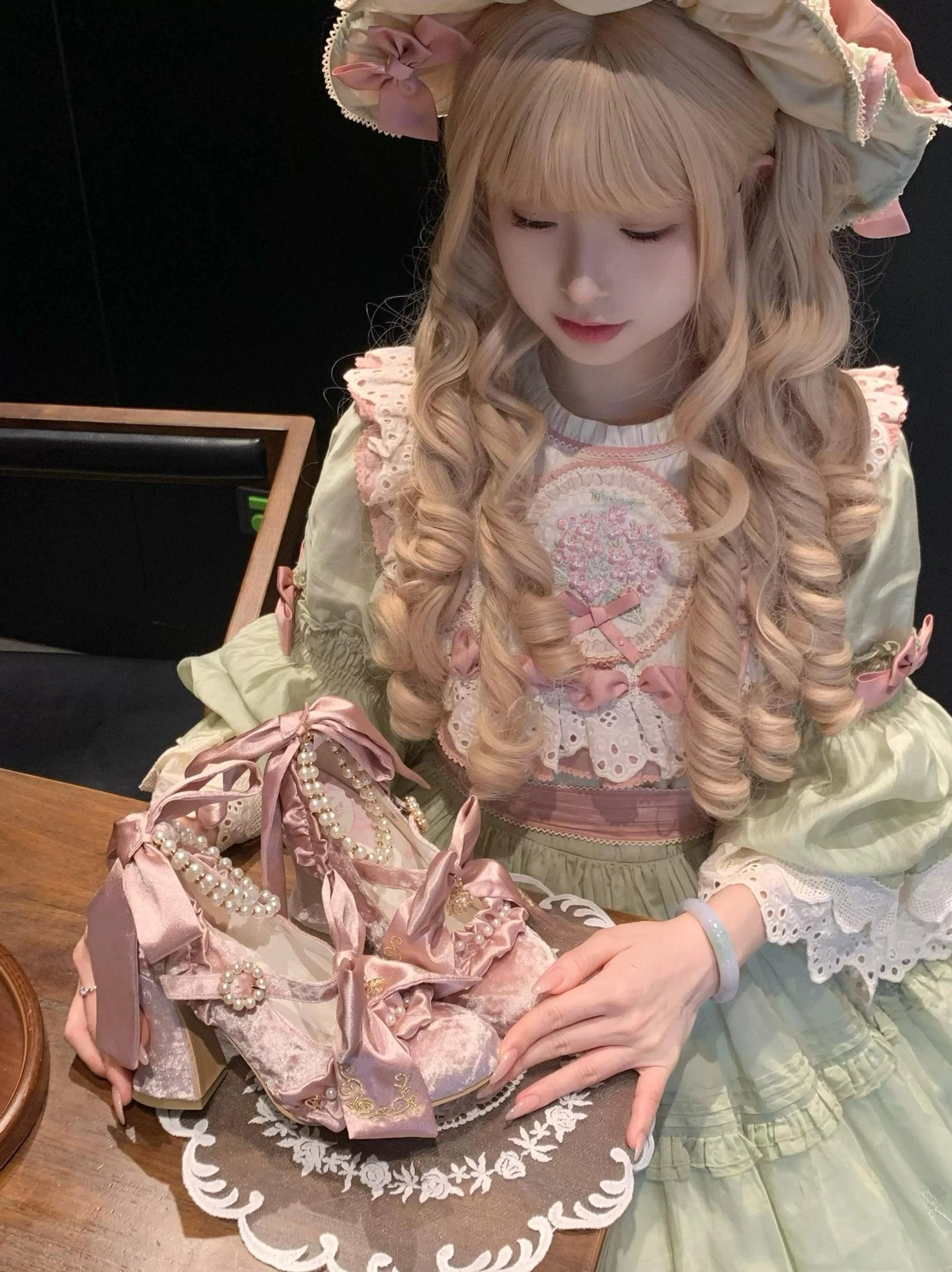 Mauve Classic Lolita block heel shoes with detachable satin bows and pearl trim, flat lay and model holding shot with green-pink Rococo-style Lolita dress and blonde curly wig on doily tray