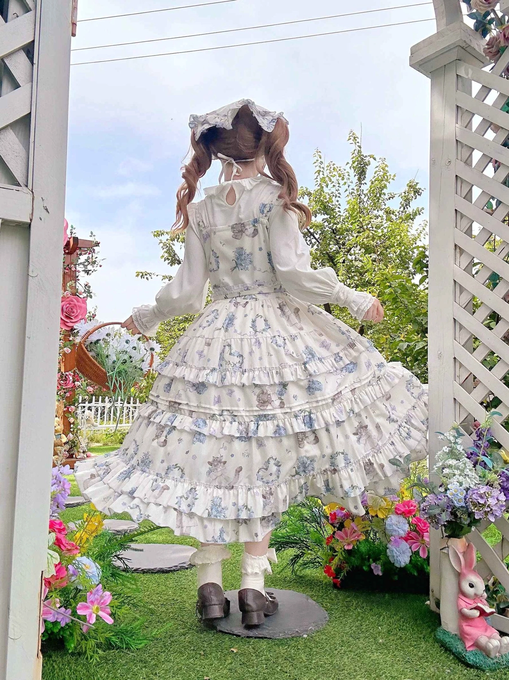 Meow Wreath Classic Lolita JSK dress back view outdoor garden trellis colorful flowers keyhole button closure multi-layered ruffled hem all-over cat and wreath print wicker flower basket