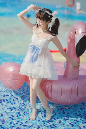 Mermaid dreams lolita swimwear two-piece three-quarter front view outdoor pool setting white base sky-blue bow ruffled tulle skirt spaghetti straps