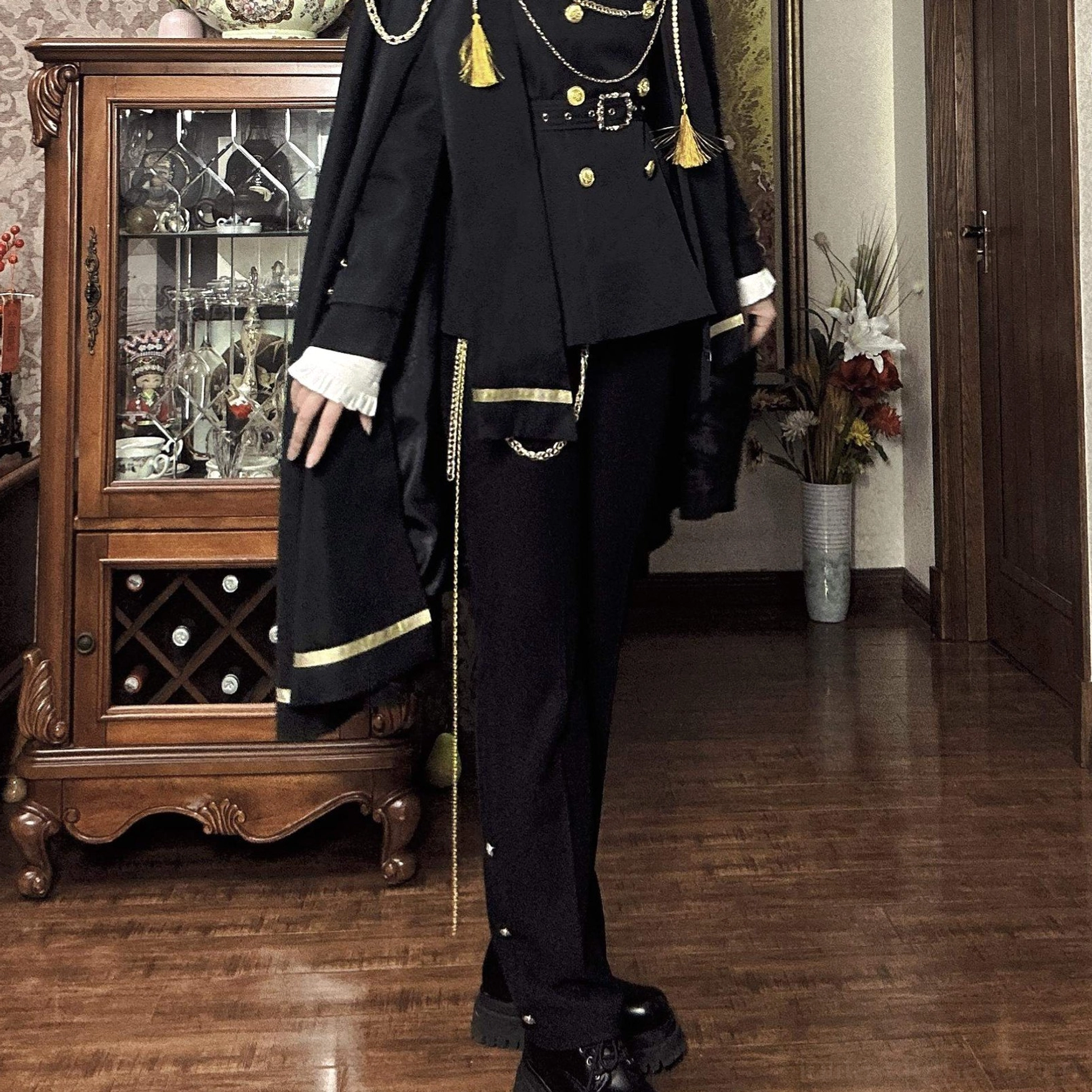 Side partial view of military Ouji lolita suit showing removable cape chain-adorned trousers and fitted black pants