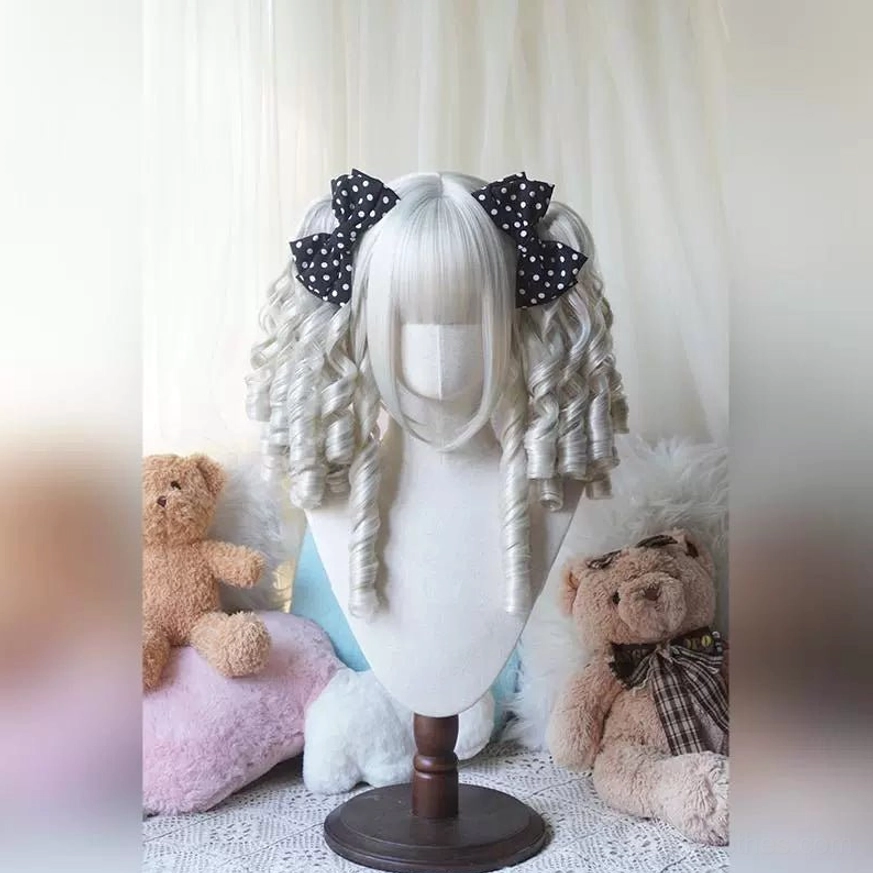 Milk tea blonde Lolita bob wig with detachable ponytails shown on mannequin with warm aesthetic plush toy background